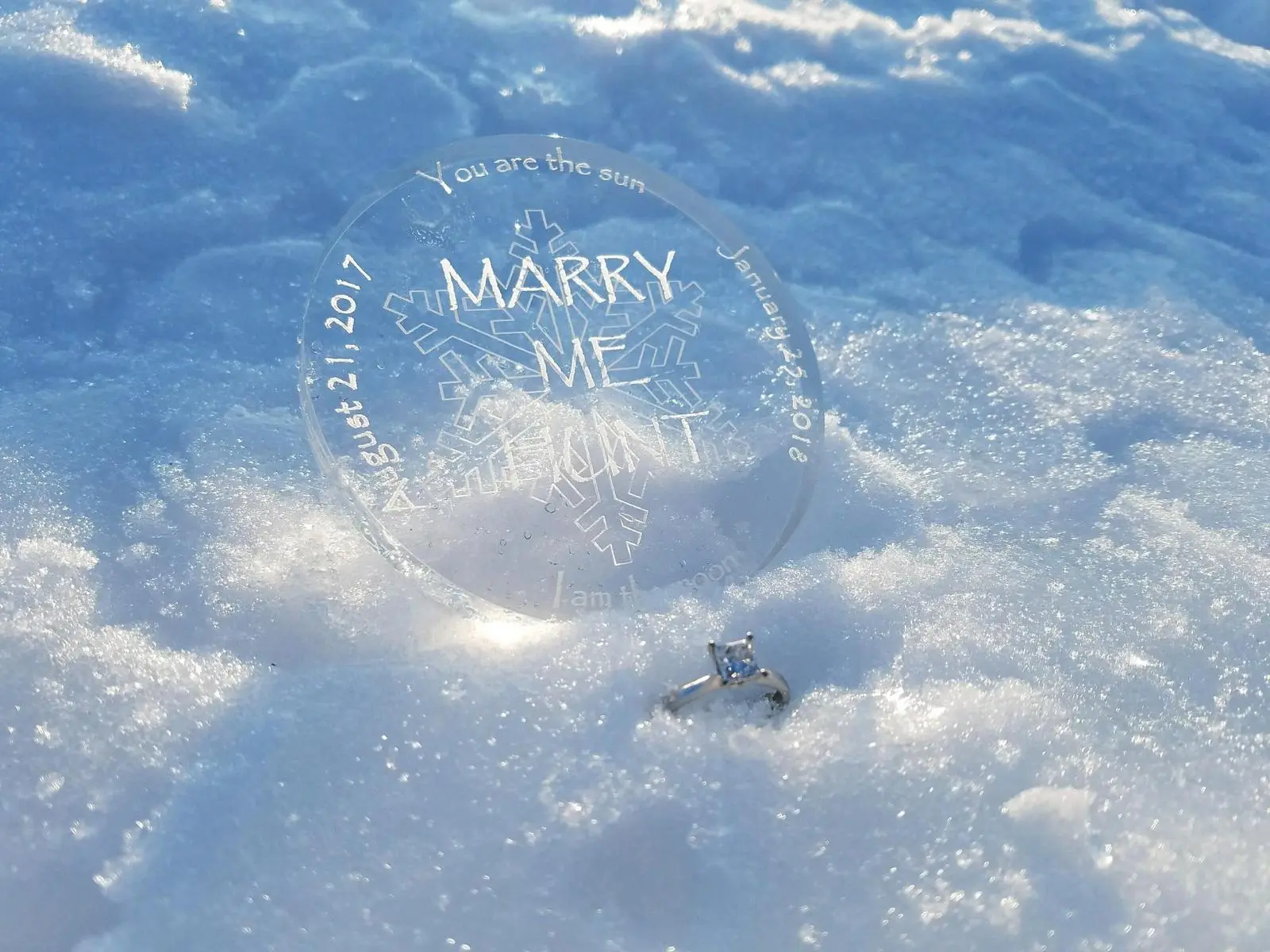 Jana Armstead had this acrylic medallion made for her "Marry Me Hunt" for Brad TeGantvoort, her longtime companion and fellow Treasure Hunter, after sending him out with clues to find his "treasure" -- a flashmob of fellow Cooler Crew hunters, on Thursday, Jan. 25, 2017.. She propped the medallion in the snow along with hte enagement ring TeGantvoort gave her last summer. (Courtesy of Jana Armstead)
