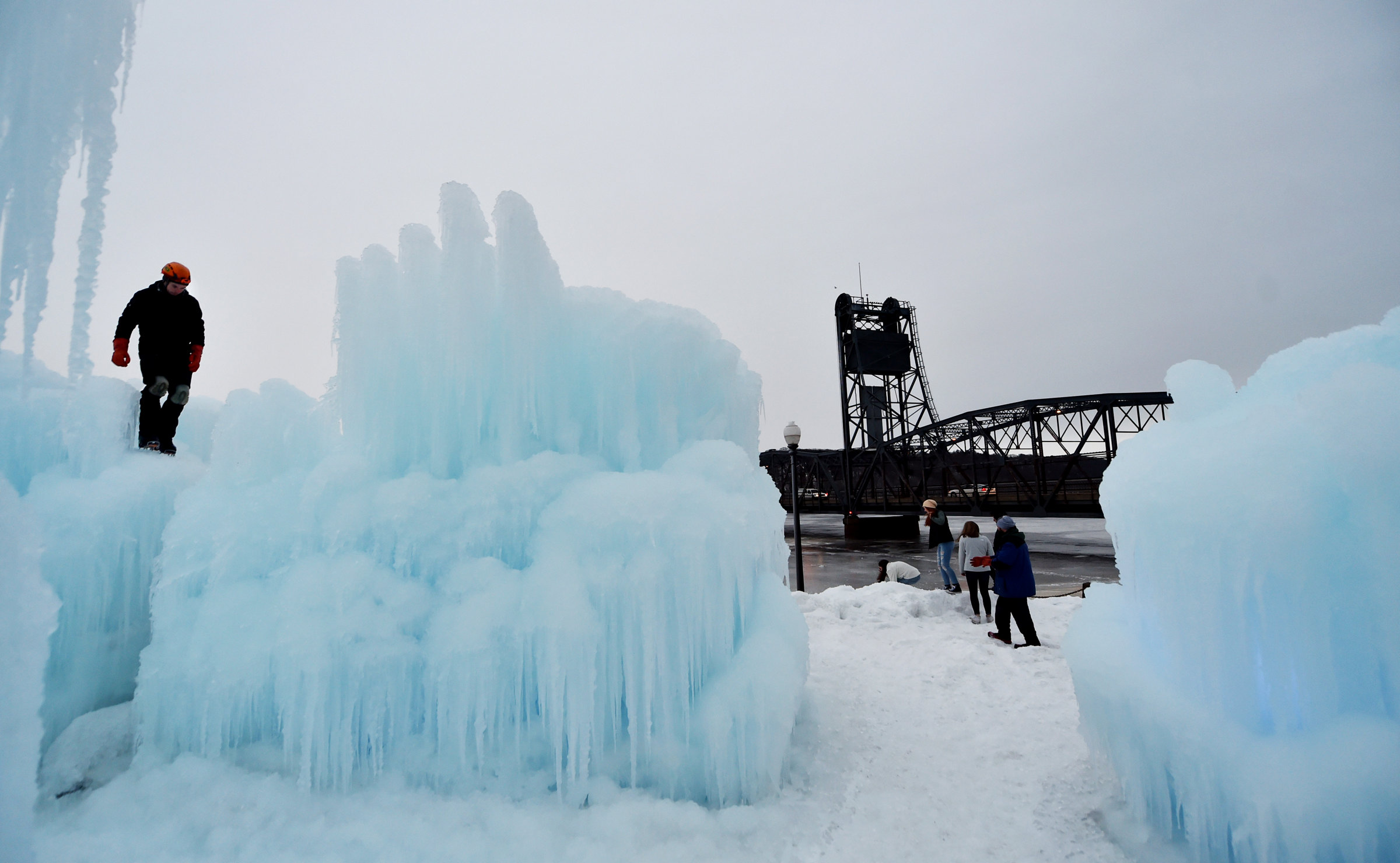 While a worker creates an ice tower, sightseers move in for a better look at the Stillwater ice castle on Dec. 30, 2016. The gigantic formation in downtown Stillwater's Lowell Park is scheduled to open to the public Jan. 6. (Pioneer Press archive: John Autey)