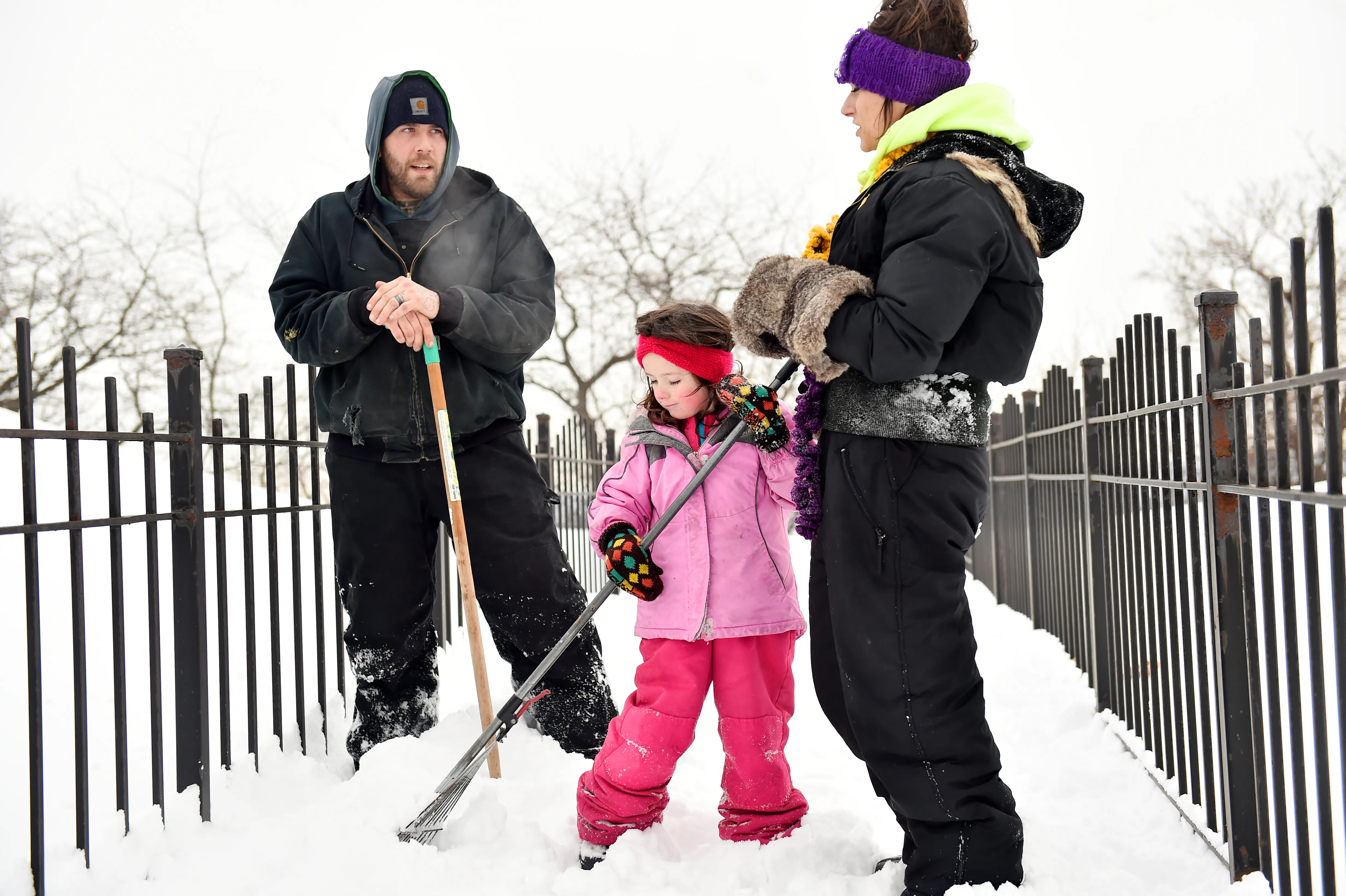 Four-year-pld Kyra Bauer helps her parents Shawn, left, and Meghan dig through the snow as the Maplewood family searches for the Pioneer Press Treasure Hunt medallion in Mounds Park in St. Paul on Wednesday, Jan 24, 2018. (John Autey / Pioneer Press)