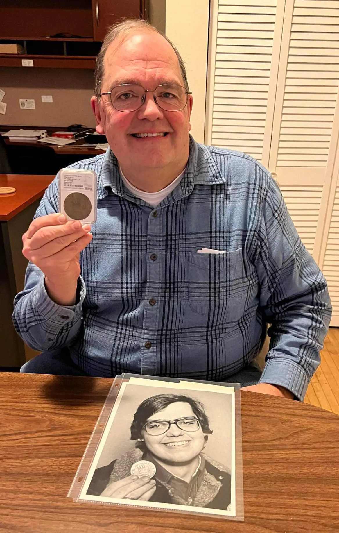 Bill Gough replicates a 1977 newspaper photo of himself holding the Pioneer Press Treasure Hunt Medallion, which he found and won a cash prize, in January 2024. After its whereabouts were unknown for several decades, a brass coin believed to be the most commonly hidden medallion and, Gough believes, the specific coin he found in a cigar box in Irvine Park surfaced unexpectedly on eBay in early 2024. (Courtesy of Bill Gough)
