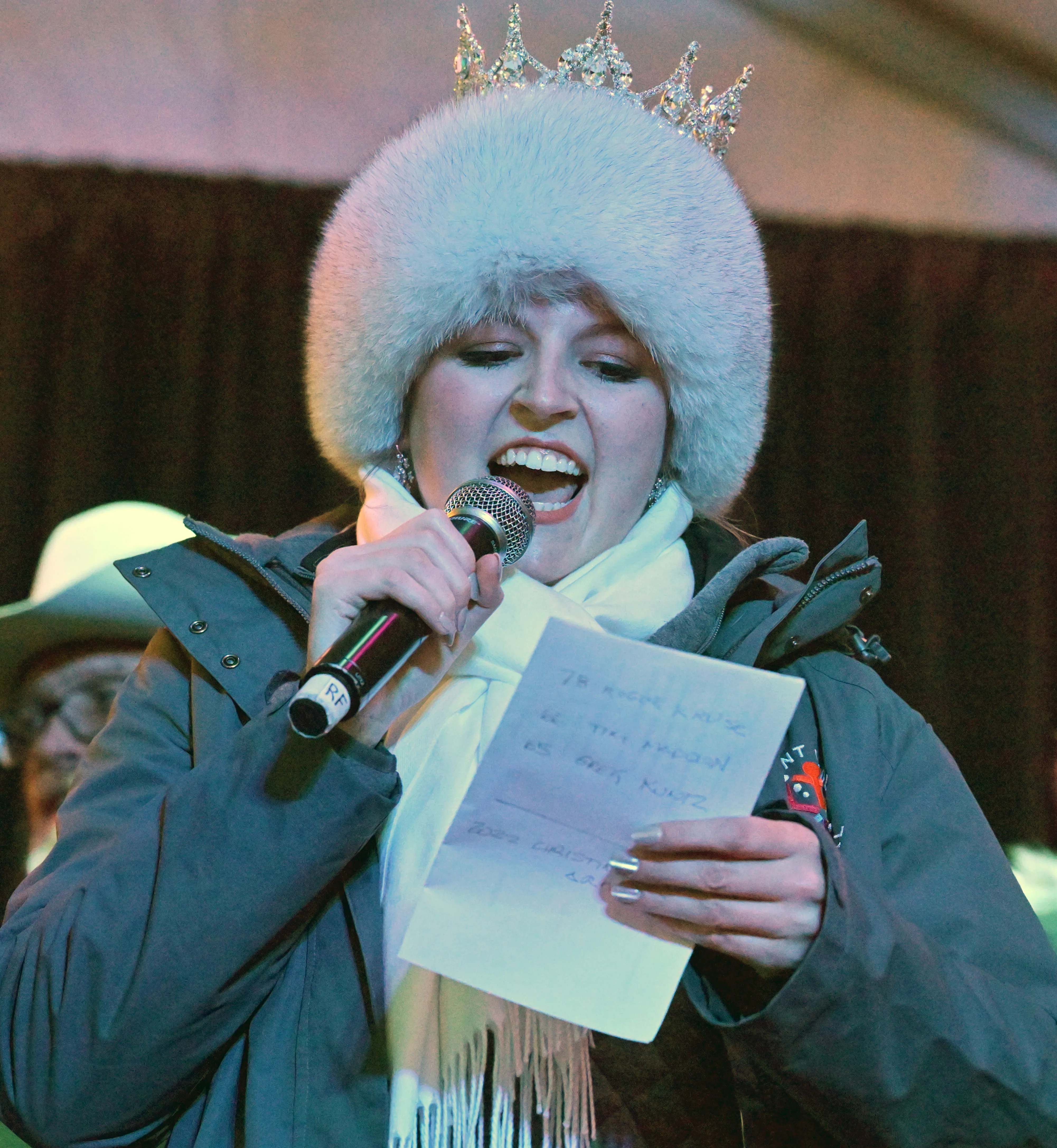 a winter carnival queen speaks to an audience using a microphone