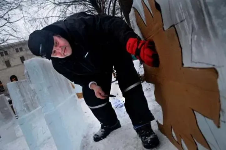 Terry Reis uses a template to etch a snowflake onto an ice block Thursday at the St. Paul Winter Carnival ice-carving competition in Rice Park. Reis and friend Rob Graham have participated in the event for 28 years. The contest ends Saturday morning; sculptures will be on display until Feb. 6.