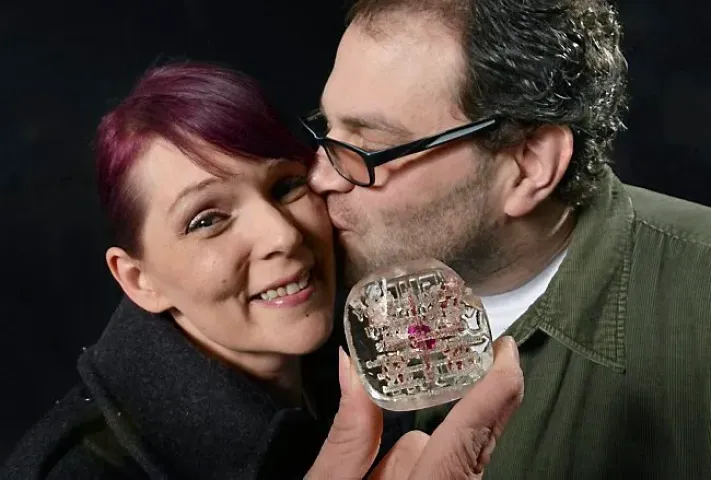 "I hit it with the pick, but he had to finish it off with the spade," said Lynn Olson-Tuma of St. Paul, getting a smooch from husband Scot Tuma after finding the Pioneer Press Treasure Hunt medallion in Cherokee Park in St. Paul on Wednesday, January 30, 2013. (Pioneer Press: Richard Marshall)