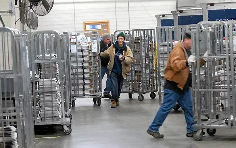 Carts of bundled papers are wheeled to waiting trucks at the St Paul Pioneer Press printing facility in St. Paul late Wednesday night, March 9. 2006. (Pioneer Press: Chris Polydoroff)
