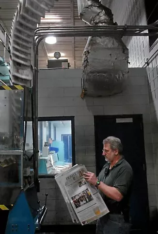 Assistant Press Manager John Galarneau takes a close look at one of the first papers of a press run at the St. Paul Pioneer Press printing facility in St. Paul late Wednesday night, March 9, 2006. He is checking for color registration, page numbers, folios, etc. (Pioneer Press: Chris Polydoroff)