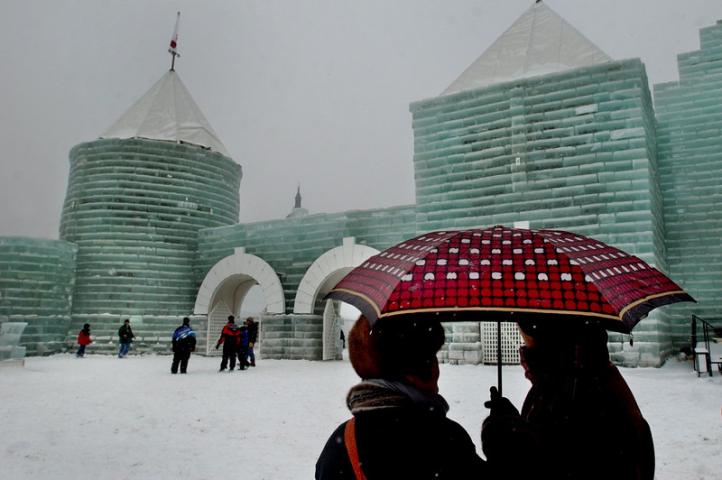 Carnival-goers walk past the 2004 Ice Palace