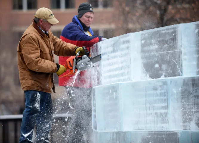 Jim Brown uses a chainsaw to cut ice blocks to size, as Dan Klingner looks on, as crews build the mini ice palace in Rice Park in downtown St. Paul, Sunday, January 24, 2016. (Pioneer Press: Scott Takushi)