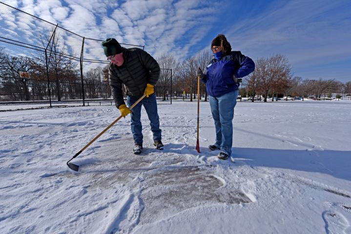 Jeff McNaughton scrapes away snow with a hoe while girlfriend Denise Olson looks on as they search for the medallion in the annual Pioneer Press Treasure Hunt at Como Regional Park on Friday. (Pioneer Press: Dave Orrick)