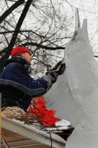 Chad Peterson of Monticello chisels away on a sailfish ice sculpture, named