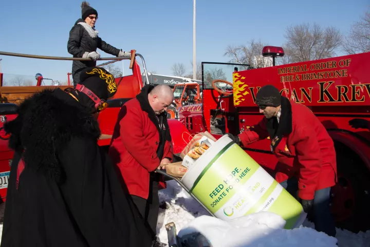 The St. Paul Vulcans pack 2 tons of donated food into five firetrucks at the State Fairgrounds on Feb. 23. (Callie Schmidt / Pioneer Press)