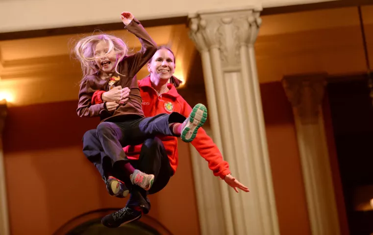 Bouncing Girl Sara LeBlanc holds 7 year-old Emme Arbuckle, from St. Paul, as she takes a turn on the blanket during the St. Paul Bouncing Team tryouts at the Landmark Center in St. Paul on Friday, February 5, 2016. (Pioneer Press: John Autey)