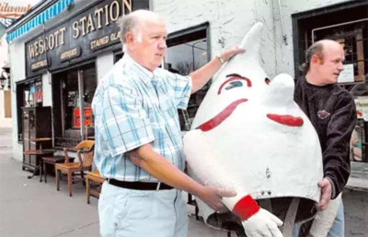 Wally Wescott, left, and his son, Kurt, place a Hi-lex gnome on a table outside their antiques store on West Seventh Street in St. Paul on Thursday.