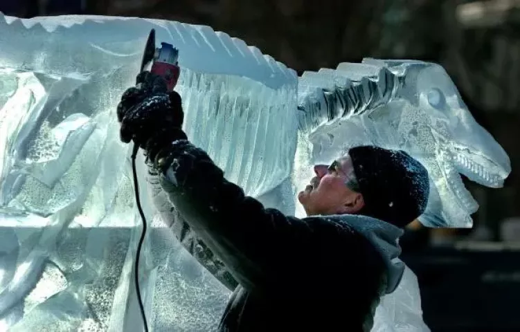 Ice carver John Franks of Blaine is covered with a coating of ice as he does detail work on the velociraptor fossil he was carving for the Science Museum of Minnesota during the Winter Carnival ice carving competition in Rice Park on Jan. 27, 2005. (Pioneer Press archives)