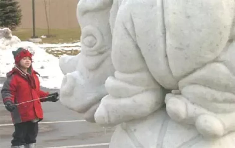 Colin Jones, 5, looks at a Rino balancing on a ball that won first place in the Saint Paul Winter Carnival Snow Sculpting contest in Roseville on Monday, January 30, 2006. Jones and his Grandmother Kathy Hastert first came on last Friday to watch the scupturers and came back on Monday to see the finished snow art.
