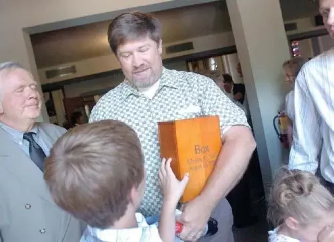 Don Boxmeyer’s son, Chris, carried a box with Don’s cremated ashes out of First Lutheran Church, August 15, 2008, following Don Boxmeyer’s service. Chris’ grandson, Shawn, felt the box (Pioneer Press Photo: Jean Pieri)