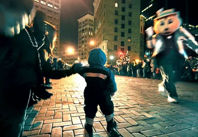 Aliya Strong, 1, with her mother Alexa Strong, dances to music in the street as Minnesota State Fair mascot "Fairchild" comes by near Rice Park during the 2012 St. Paul Winter Carnival Torchlight Parade on Saturday, February 4, 2012 on 5th Street in downtown St. Paul. (Pioneer Press: Sherri LaRose-Chiglo)