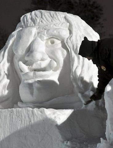 Pat Mogren works on a gigantic ogre's head at the State Fairgrounds in Falcon Heights, on Tuesday, January 21, 2014. The sculpture, at the site of the St. Paul Winter Carnival snow sculpture competition on Machinery Hill, depicts three ogres and a dragon. Mogren and White, who have carved snow sculptures all over the country, have been working on the carving, which measures 15 feet high by 50 feet long, since Monday January 13th. (Pioneer Press: Scott Takushi)