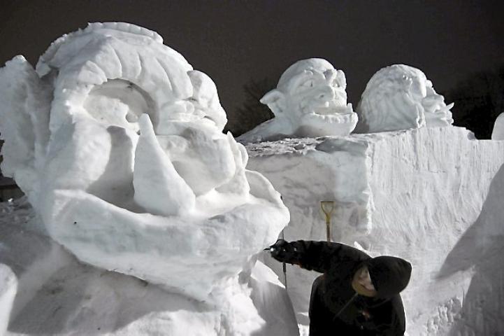 David White scrapes the chin of a enormous ogre head, part of a gigantic snow carving at the State Fairgrounds in Falcon Heights, on Tuesday, January 21, 2014 which he is carving with Pat Mogren. The sculpture, at the site of the St. Paul Winter Carnival snow sculpture competition on Machinery Hill, depicts three ogres and a dragon. Mogren and White, who have carved snow sculptures all over the country, have been working on the carving, which measures 15 feet high by 50 feet long, since Monday January 13th.
