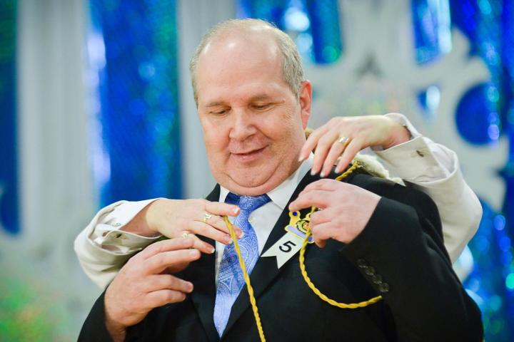 Greg Pluff gets a bit of assistance with his royal paraphernalia after being chosen as King Winter the 56th during the Senior Royalty Coronation ceremony. (Pioneer Press: Ben Garvin)