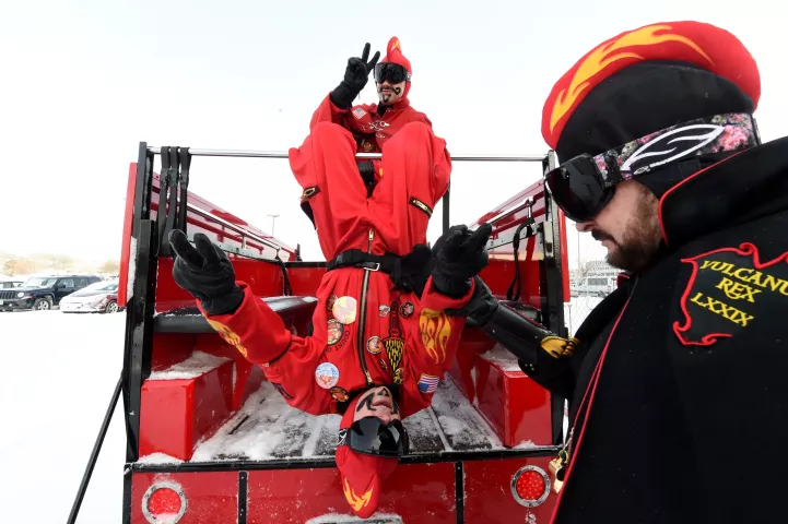 Jeff MacDonald, Count of Ashes is helped up by John Utermoehl, Vulcanus Rex, right, as he swings from the Vulcan truck. (Pioneer Press: Jean Pieri)