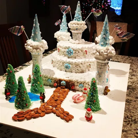 Beatrice Bucholz of Woodbury: "This Ice Castle was made in December 2017 for a work contest. This ice castle took first place at my work contest. It took us about 1 week to construct. The castle, its columns, and trees are constructed out of ice cream cones and Rice Krispies bars. The whole castle is covered in Marshmallow Fluff and marshmallows. Royal Icing was used as 'glue' to for the edible gingerbread people and sprinkles."