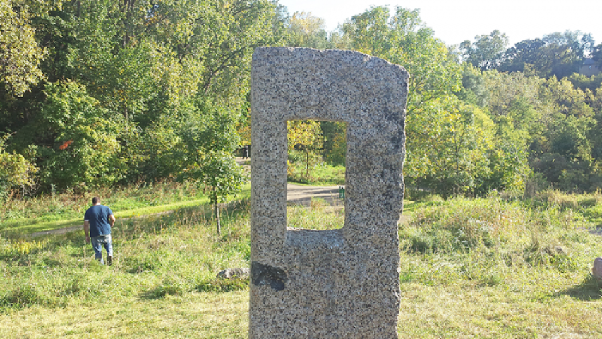 The Harvest Festival medallion was found by looking south through a hole in a rock in “Swede Henge,” a sculpture at the north end of the park. Looking through the hole, there is a green pole with a large tree to the left. The medallion was hidden in a bread bag in the tree. courtesy of Ed Brodie