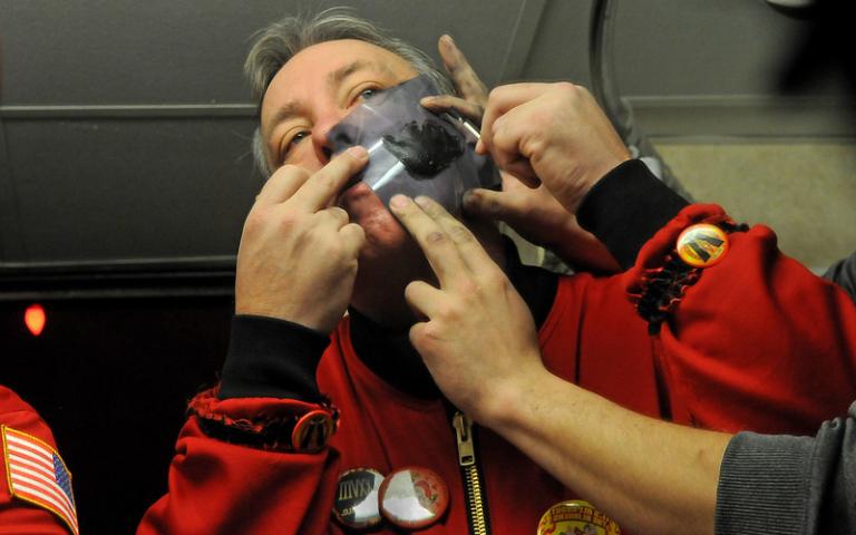 Duke of Klinker, Leigh Halvorsen gets some help putting a stencil on his cheek in a hotel room bathroom before going out with the vulcans in St. Paul on Wednesday Jan. 28, 2015.  (Pioneer Press: Jean Pieri)