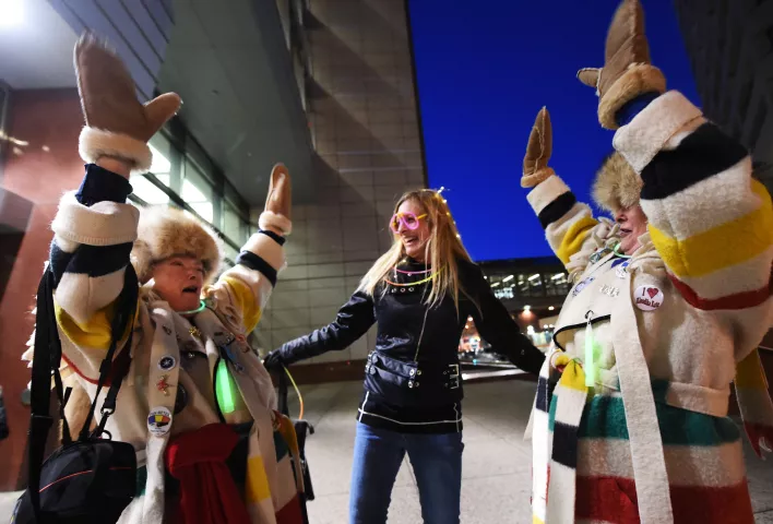 Twin sisters Joan Kelly, left, and Jane Lonergan, right, sing happy birthday to Rebecca Becke of Afton at the start of the St. Paul Winter Carnival Moon Glow Parade in St. Paul on Thursday, Jan. 28, 2016.  (Pioneer Press: John Autey)