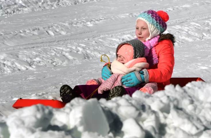 Sisters Alayna Brozek, 8, and Leyla Brozek, 3, of Centerville, ride together down the giant snow slide at the Snow Park at the Minnesota State Fairgrounds. on Sunday January 29, 2017. (Pioneer Press: Scott Takushi)