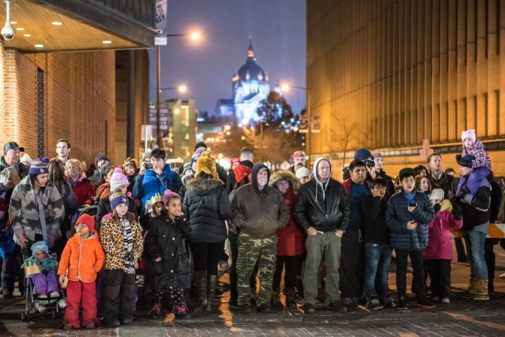 Spectators watch the Winter Carnival Vulcan Victory Torchlight Parade travel along Fifth Street in downtown St. Paul on Saturday, Feb. 4, 2017. The Cathedral was lit for the Red Bull Crashed Ice event taking place the same night. (Pioneer Press: Andy Rathbun)