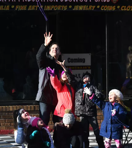 Jeff Sanders, left, of Eagan, with his kids Eli, Hannah and Emma try to catch some beads tossed their way. (John Autey / Pioneer Press)