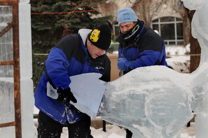 Greg Schmotzer, left, of Hastings and Chris Swarbrick of Hudson, Wis. put a head on a wolf of their ice sculpture "Dream Chaser." (Pioneer Press: Jean Pieri)