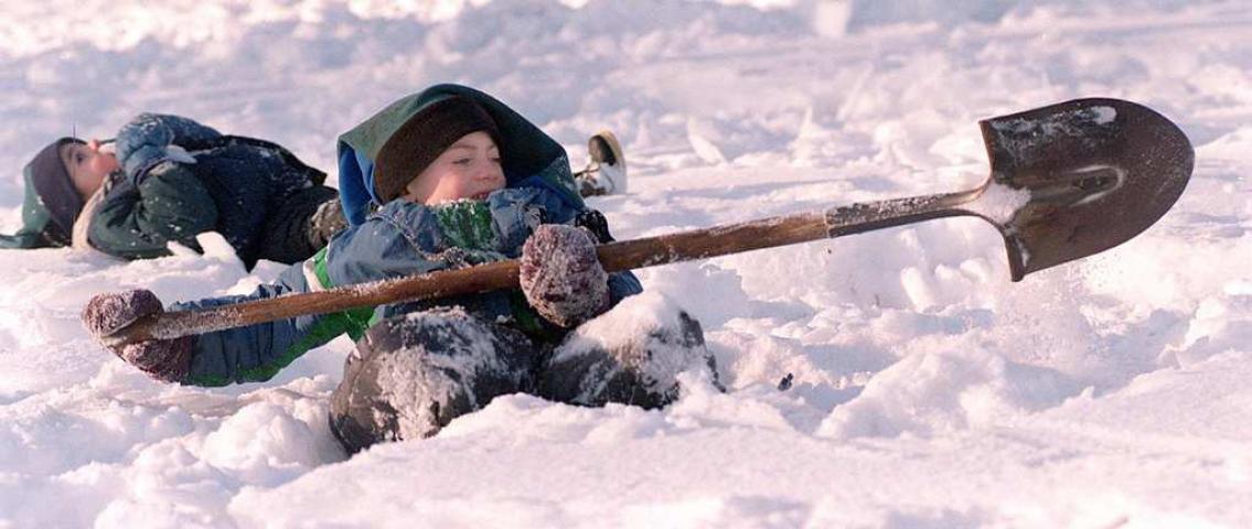 Max Bollman, 6, searches for 1999's medallion near the fence outside Como Zoo while his brother Nick, 5, takes a snow break behind him. (Pioneer Press file photo)