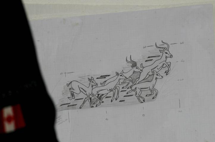 Deneena Hughes refers to a drawing of impalas as she works on her ice sculpture Friday. This is her 18th year of carving with her husband, Paul Hughes.  (Pioneer Press: Jean Pieri)