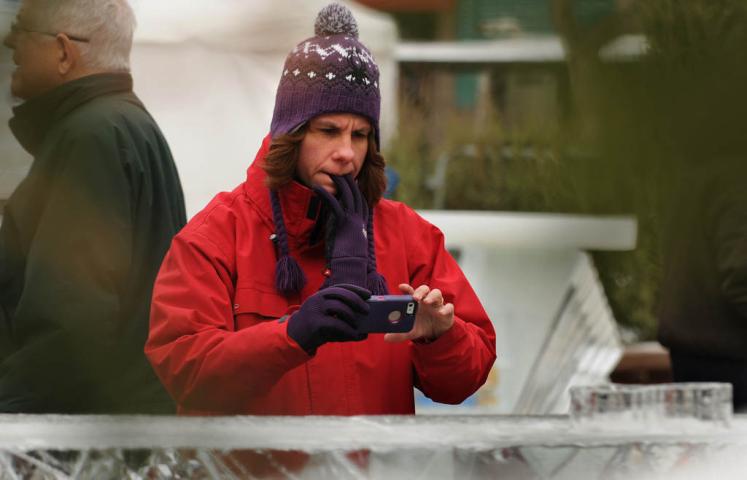 Melissa Proud of Virginia Beach, Virginia, holds her gloves in her mouth to take a photo of ice sculptures. \"It\'s pretty neat,\" she said. She is in Minnesota for a wedding.  (Pioneer Press: Jean Pieri)