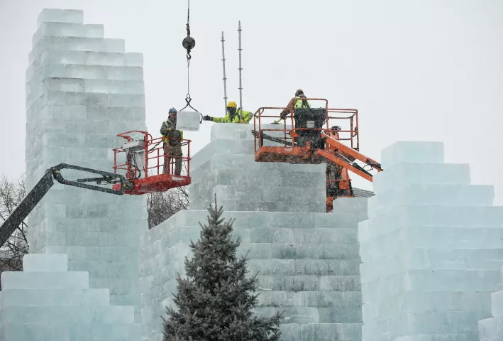 Construction workers place ice blocks on the central tower of an ice palace being built for the St. Paul Winter Carnival in St. Paul’s Rice Park during a snowstorm on Monday, Jan. 22, 2018. (John Autey / Pioneer Press)