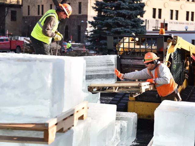 Chad O’Flanagan, left, and Taylor Dolan wth Park Construction Company muscle 650 pound blocks of ice off pallets at the site of the St. Paul Winter Carnival Ice Palace in Rice Park in St. Paul on Monday, Jan. 8, 2018. Flatbed trucks deliver 44 blocks at a time as the crews get ready to start building the Ice Palace starting Tuesday evening. (Pioneer Press / John Autey)