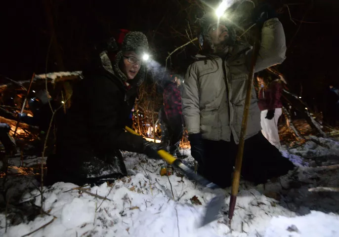 Twins Tess, left, and Tommy McNamara, originally from Shoreview, work a patch of snow near a large upturned tree as they search for the Pioneer Press Treasure Hunt medallion at Bald Eagle-Otter Lake Regional Park late Wednesday, Feb. 3, 2016. (Pioneer Press: John Autey)