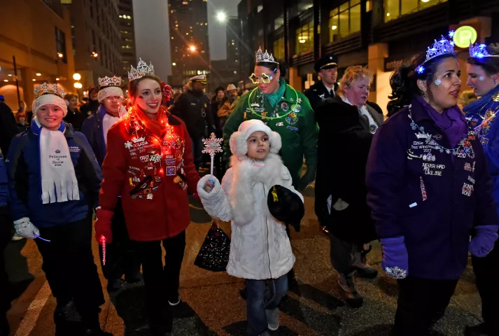 Marchers walk down Sixth Street in the St. Paul Winter Carnival Moon Glow Pedestrian Parade in St. Paul on Thursday, Jan. 25, 2018. With luminaries in hand to light the way, carnival dignitaries, ambassadors and organizers walk with local business leaders from the Securian Building on Sixth and Robert to Rice Park. (Jean Pieri / Pioneer Press)