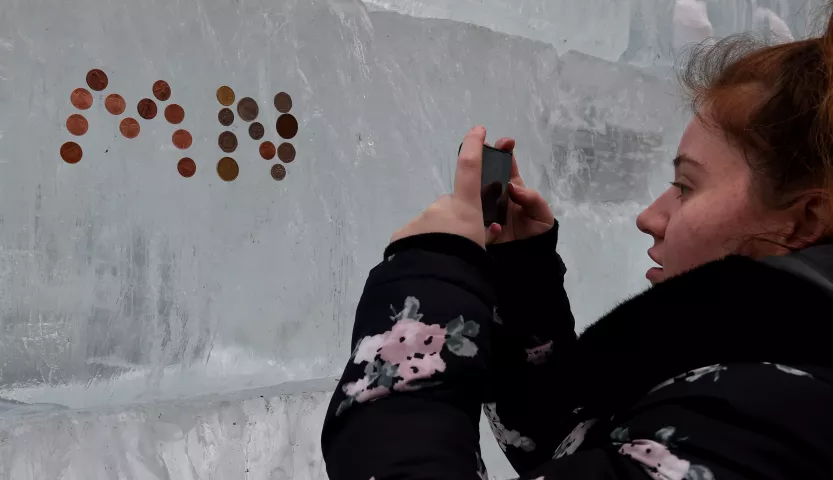 Morgan Duthart from Scotland takes a picture of the MN (for Minnesota) in coins she and her friend put on the ice palace before the St. Paul Winter Carnival Moon Glow Pedestrian Parade in St. Paul on Thursday, Jan. 25, 2018. She is visiting her friend from summer camp. This year, the community was offered a chance to be a part of the Ice Palace with the Buy a Block initiative to help build the PeopleÕs Palace by purchasing ice blocks and helping us raise funds to support the community-driven project. (Jean