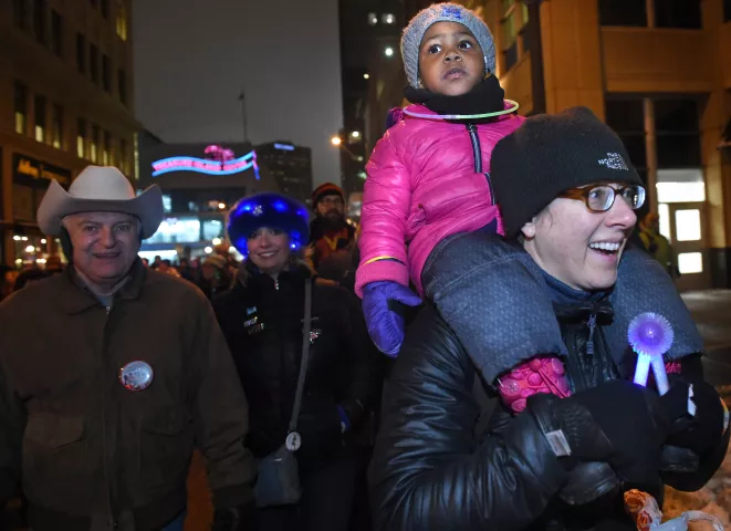 Keri Just, 2, rides atop her mom, Clara Just's shoulders at the St. Paul Winter Carnival Moon Glow Pedestrian Parade in St. Paul on Thursday, Jan. 25, 2018. "It's our tradition to come up each year," said Clara, an Evanston, Illinois cop who used to live in St. Paul. (Jean Pieri / Pioneer Press)