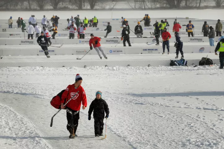 Rex Frazier, 9, right, walks and talks with his dad, Mark Frazier, 43, Excelsior, as they leave after Mark competed with an Eden Prairie Old Timers hockey team, in the 7th Annual U.S. Pond Hockey Championships, Friday, January 20, 2012, on Lake Nokomis in Minneapolis. (Pioneer Press: Jean Pieri