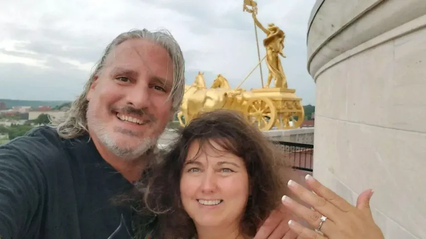 Jana Armstead, right, holds up her engagement ring from Brad TeGantvoort near the Quadriga on a roof of the Minnesota Capitol on Aug. 21, 2017. TeGantvoort chose the day of the Great American Solar Eclipse to propose — again — and the two soon after got stuck on the terrace, locked out until the next tour arrived. (Courtesy of Jana Armstead)