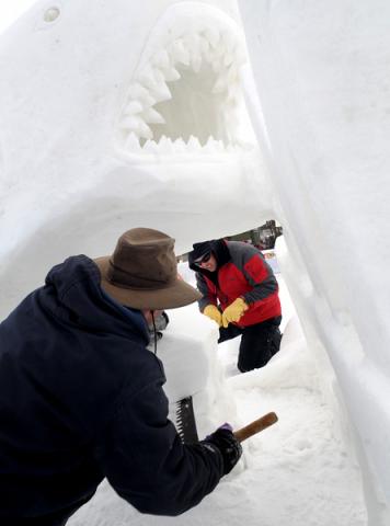 Team MS Krackers' Kurtis Klett, foreground, and Keith Klett, back, work on taking out snow with an old logging saw as they put the final touches on their "Bite MS" sculpture. (Pioneer Press: Sherri LaRose-Chiglo)