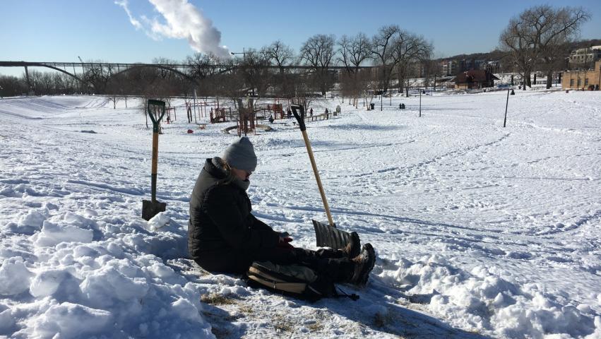 A treasure hunter sits in a cleard area of Harriet Island