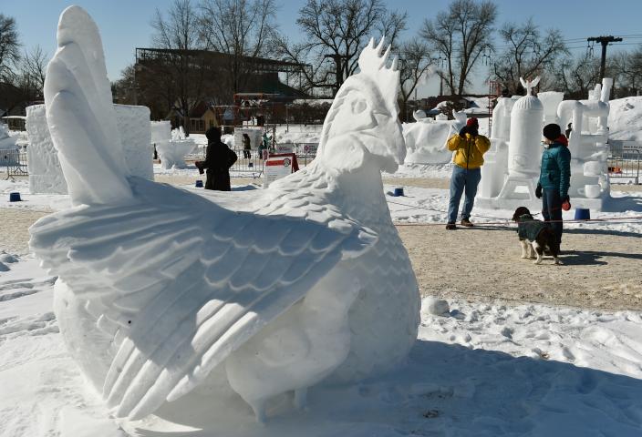 Darrell Staley takes a picture of the Eggloo snow sculpture while his wife Jayne and dog, Dotti, wait at the Vulcan Snow Park at the Minnesota State Fair in Falcon Heights on Sunday, Feb, 11, 2018. The Alexandria couple were in town house sitting for their daughter and said, "We thought we'd see all this before it melts." (John Autey / Pioneer Press)
