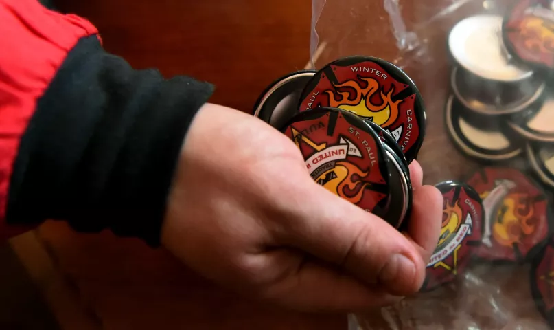 Vulcans scoop up Vulcan buttons to hand out at the five stops they have scheduled for Wednesday. (Pioneer Press: Jean Pieri)