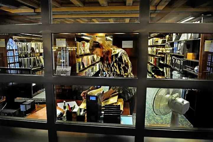 Nancy Tschida searches through 1956 Winter Carnival newspaper clippings in the St. Paul Room, a climate-controlled room on the second floor of Central Library in St. Paul on Thursday, Jan. 15, 2015. Tschida is researching a silent film her aunt made of the Winter Carnival. (Pioneer Press: Jean Pieri)