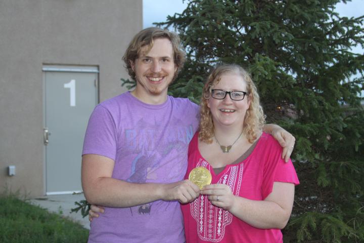Husband and wife Landon and Rachel Larivee found this year’s Heimatfest medallion on Monday. The gold was hidden under a pine tree next to the middle school playground.  PHOTO BY RACHEL WITTROCK