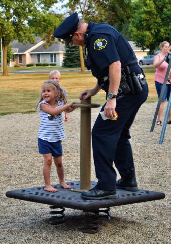 Litchfield Police Officer Gary Gruenke joined a youngster on playground equipment during a block party at Sunrise Terrace Park in 2017.  Photo by Samuel Carlson